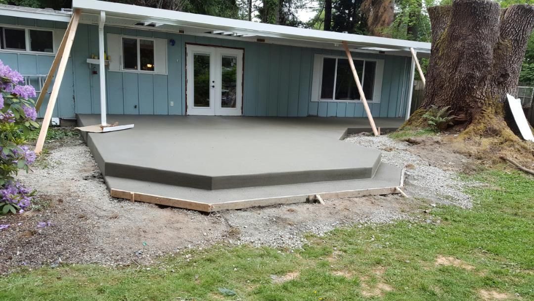 Freshly poured concrete patio with integrated step and smooth finish