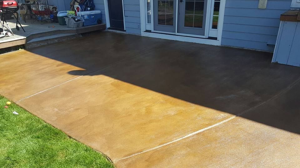 Decorative concrete flatwork adjacent to lawn and deck area
