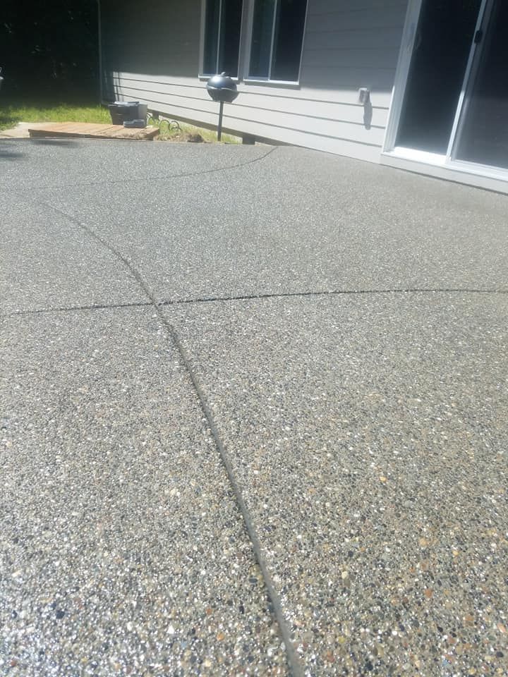 Large exposed aggregate concrete patio with curved control joint layout