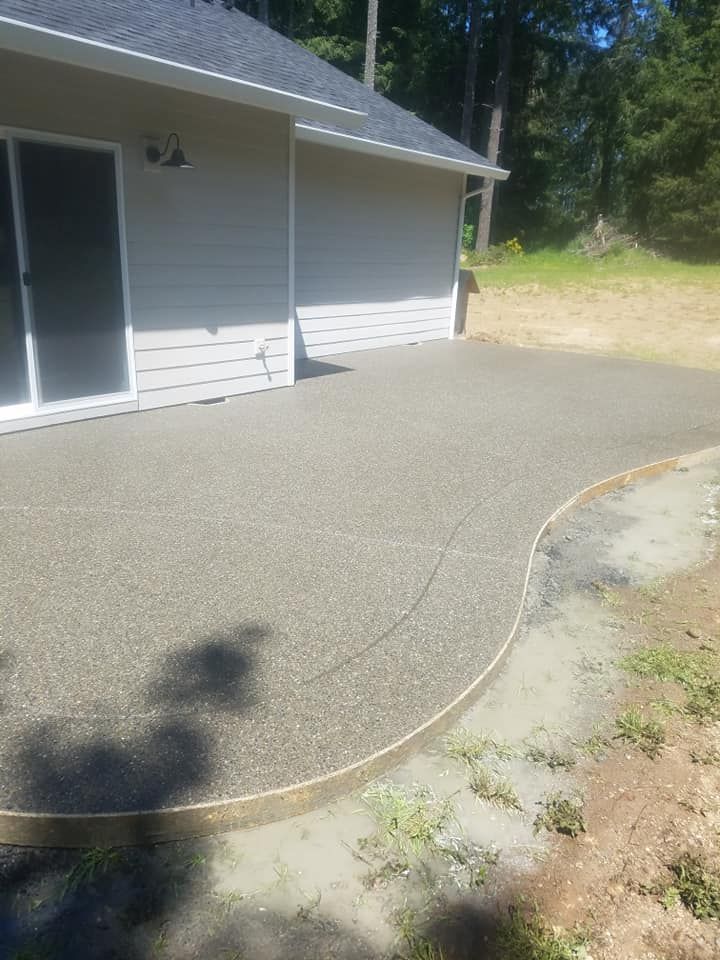 Curved exposed aggregate concrete patio with decorative rounded edge