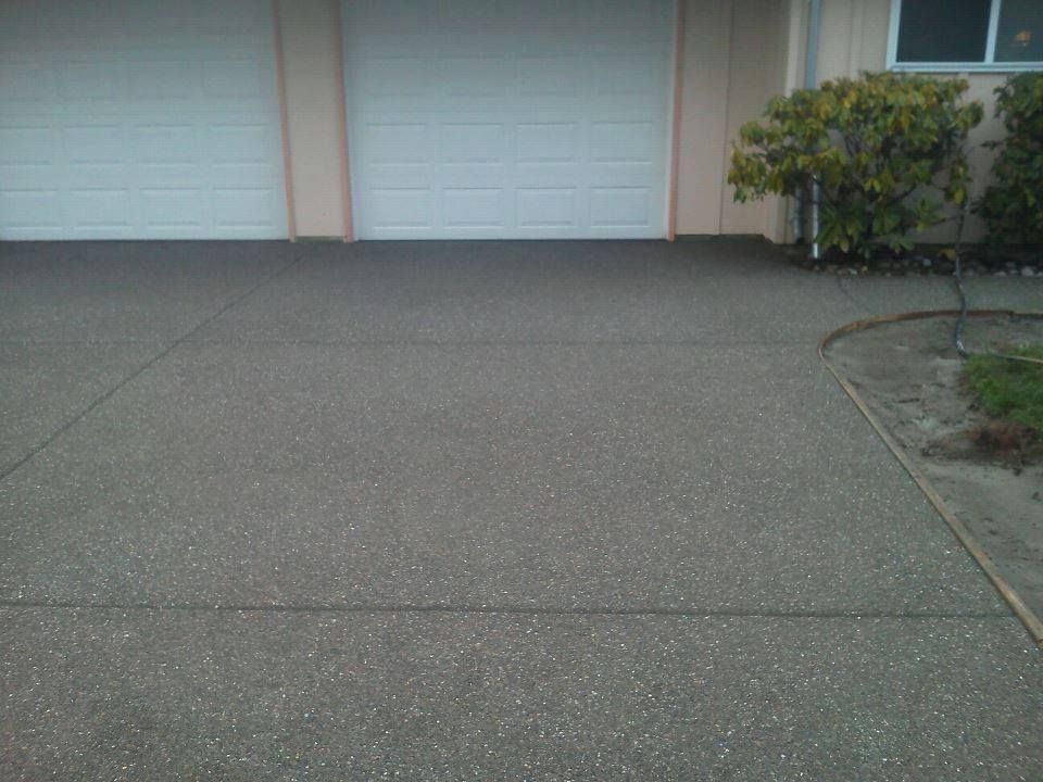 Exposed aggregate concrete driveway in front of double garage