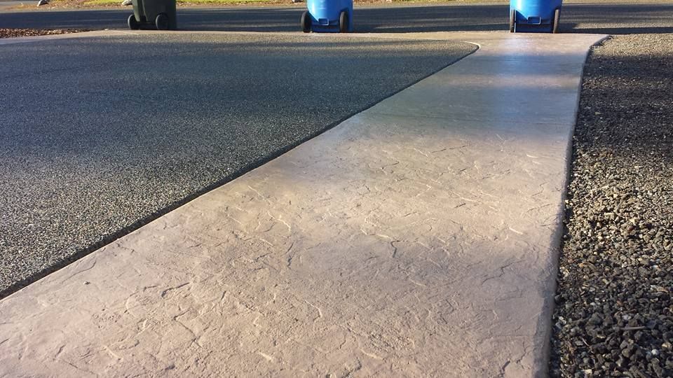Decorative stamped concrete border adjacent to asphalt roadway