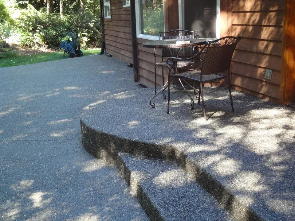 Exposed aggregate concrete patio with curved step detail