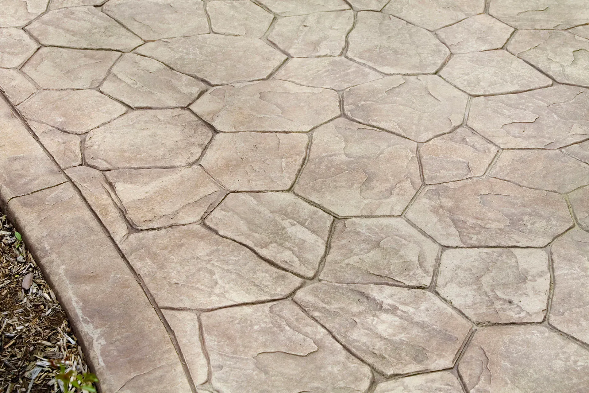 Concrete patio surface with irregular shaped stone pattern
