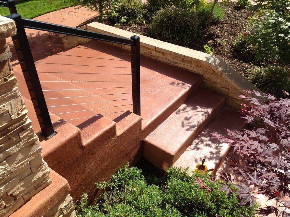 Stained concrete patio steps with textured finish and modern railing