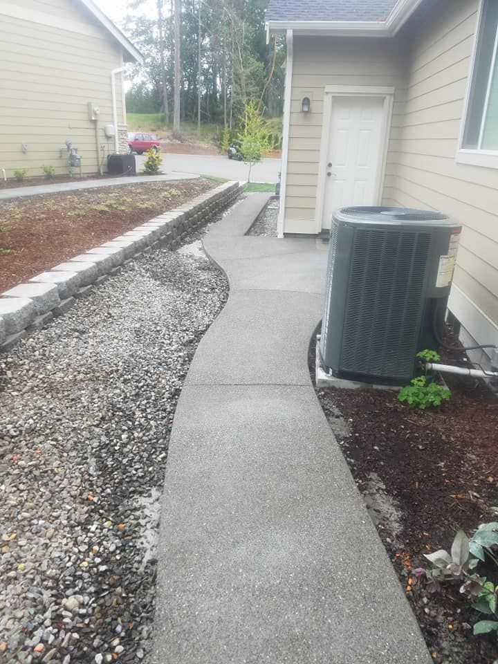 Side yard concrete installation bordered by gravel drainage bed