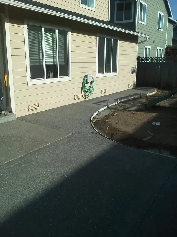 Exposed aggregate concrete walkway along residential side yard