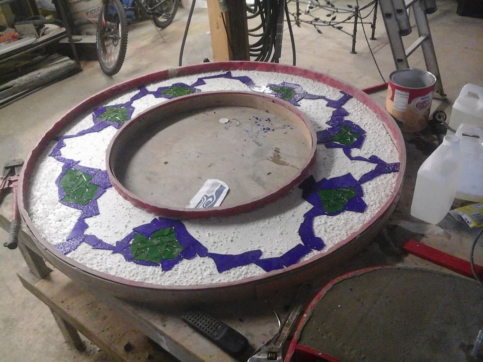 Custom circular concrete tabletop with decorative inlay pattern