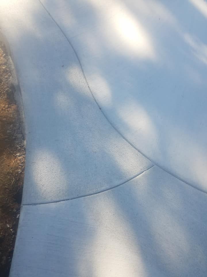 Smooth broom-finished concrete walkway with flowing curved design

