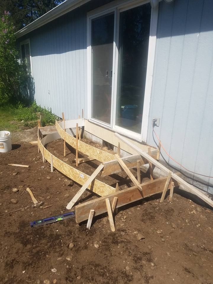 Newly poured concrete patio with curved layout and stained border accent