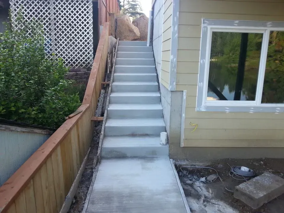 Poured concrete staircase with adjoining sidewalk at hillside home