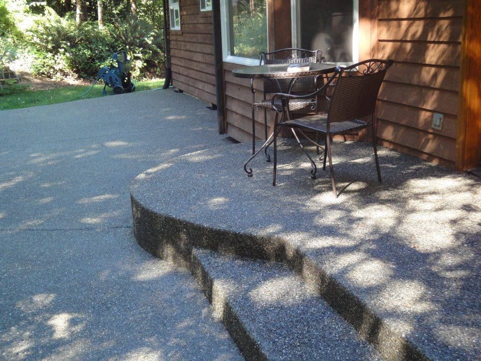 Decorative aggregate outdoor living space with seamless stair integration
