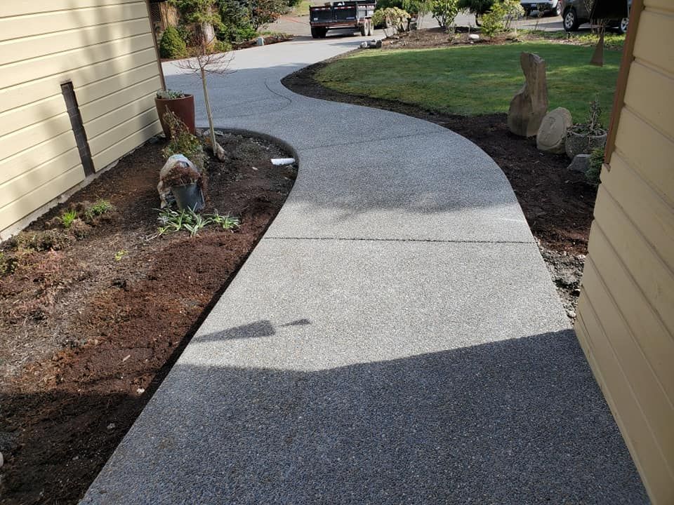 Seamless aggregate concrete sidewalk connecting entry to driveway