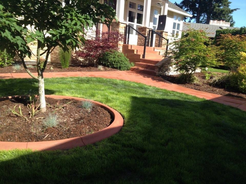 Stained and curved concrete walkway leading to front porch steps