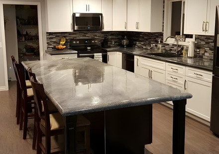 Large custom metallic epoxy concrete kitchen island with polished finish and dark wood base