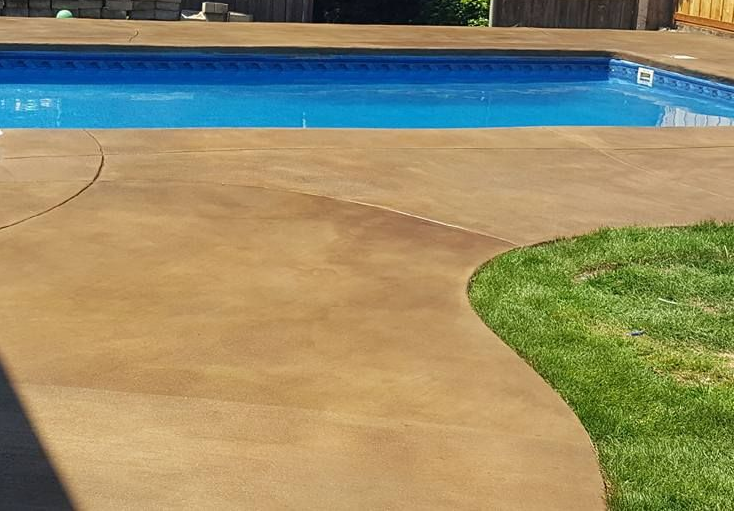 Residential backyard pool patio with custom concrete finish