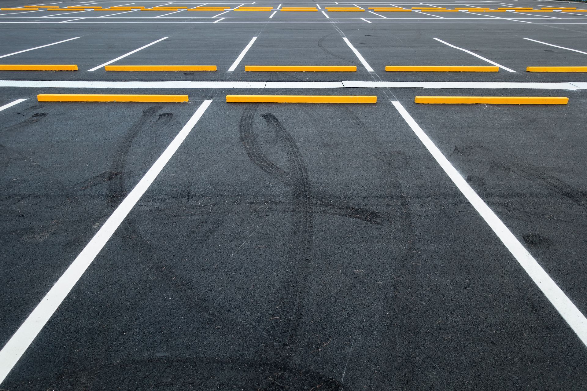 Empty car parking lots with marked parking spaces, located in an outdoor public parking area.