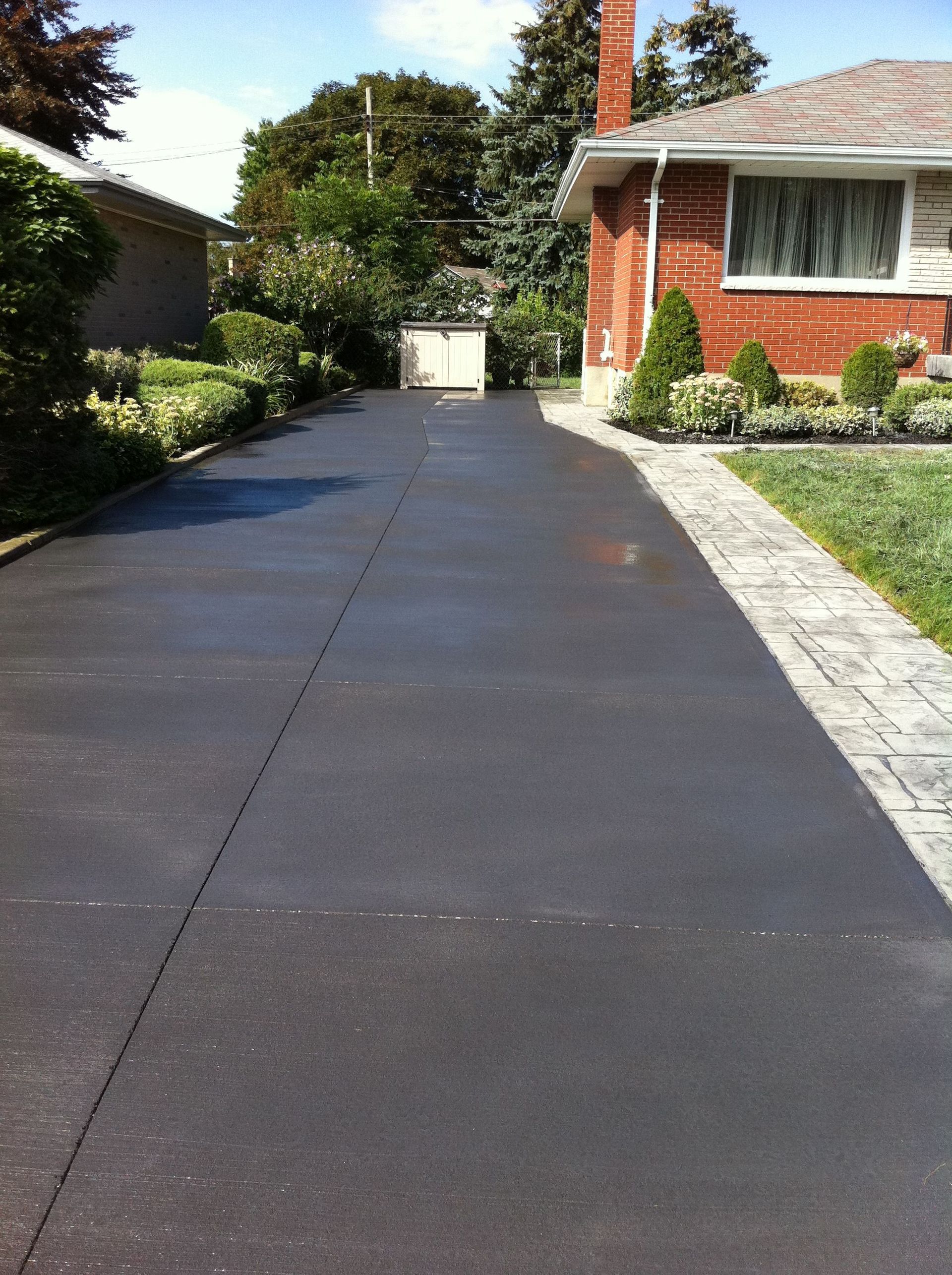 An asphalt driveway being sealed to protect and extend its lifespan.