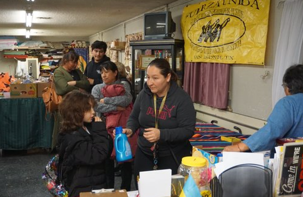 A group of people are standing around a table in a room.