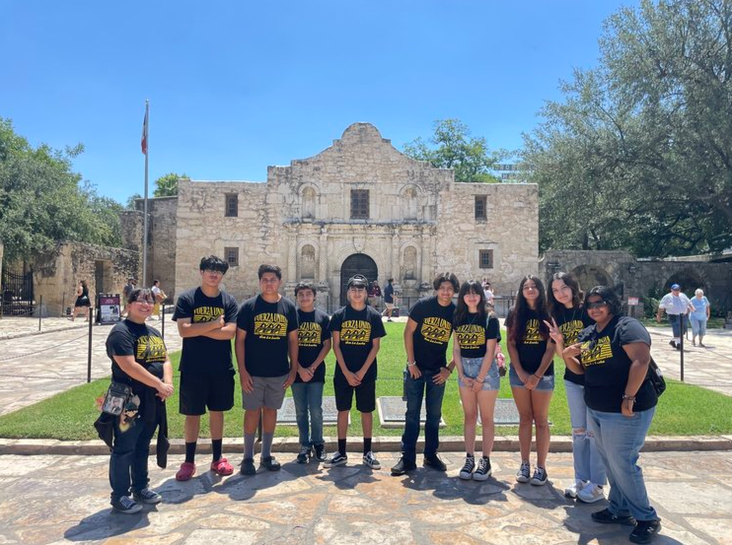 A group of people are posing for a picture in front of a building.