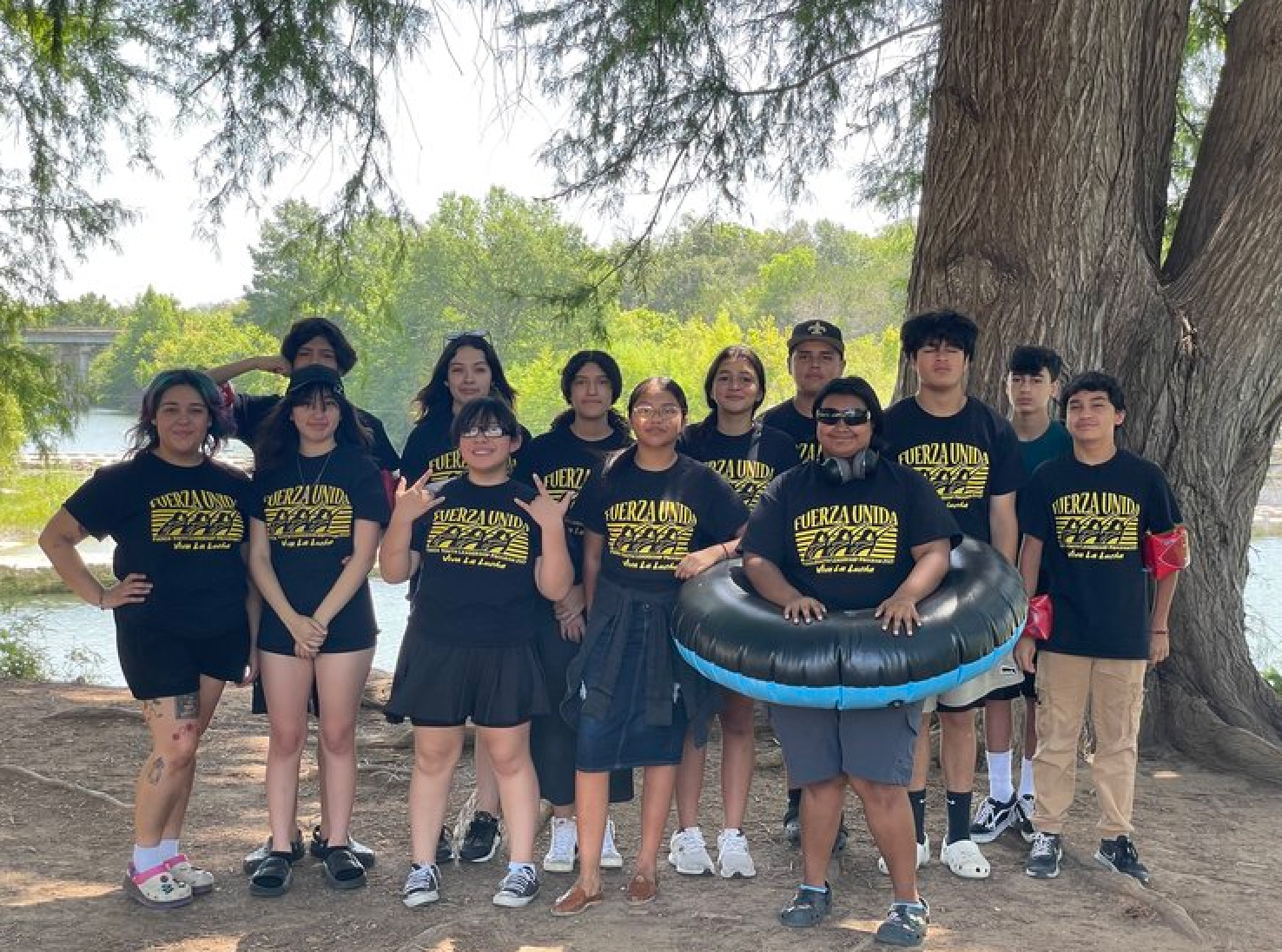 A group of people are posing for a picture in front of a tree.