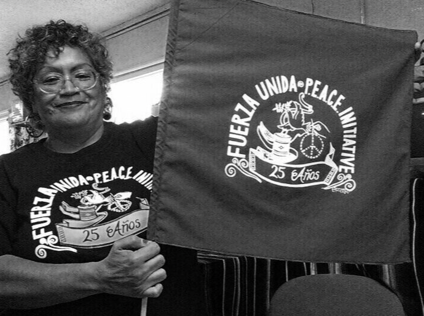 A woman holding a flag that says fuerza unida peace initiative