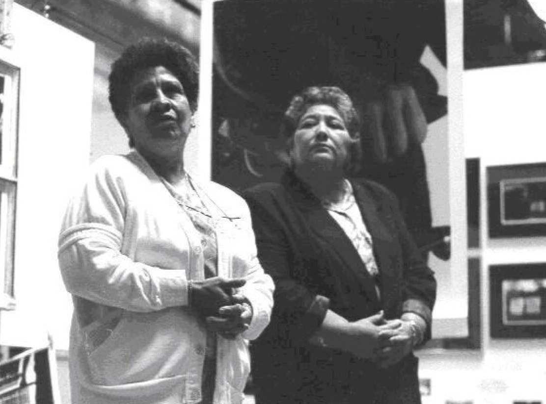 A black and white photo of two women standing next to each other