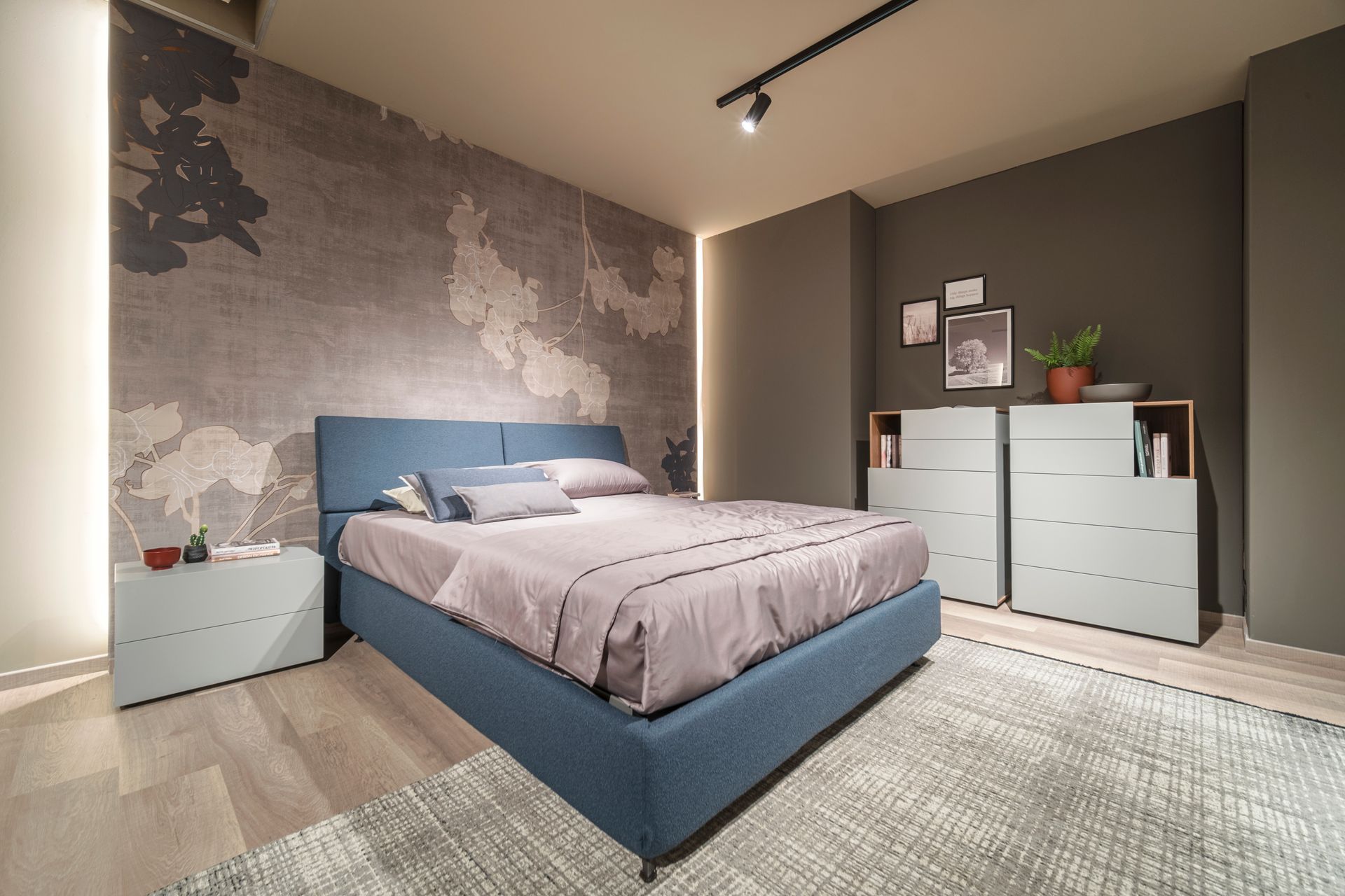 Una camera da letto con un letto, una cassettiera, un comodino e un tappeto.