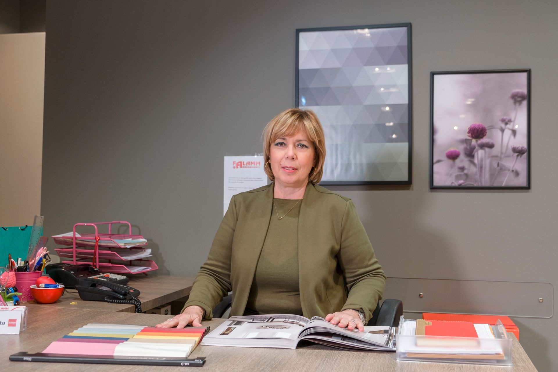 Una donna è seduta a una scrivania con un libro sopra.