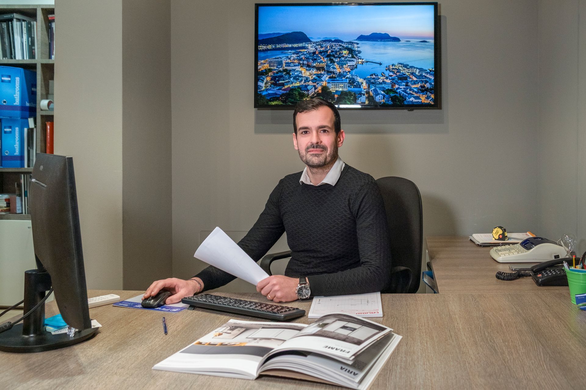 Un uomo è seduto alla scrivania davanti a un computer.