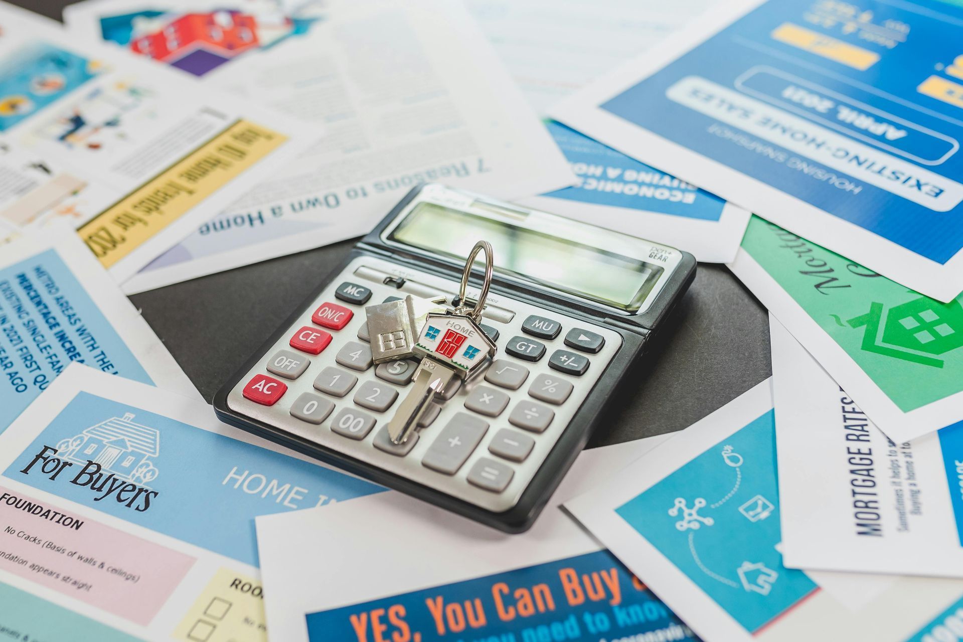 Calculator on scattered financial flyers and bank statements with blue and red accents