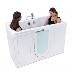 Two women are sitting in a bathtub with a glass door