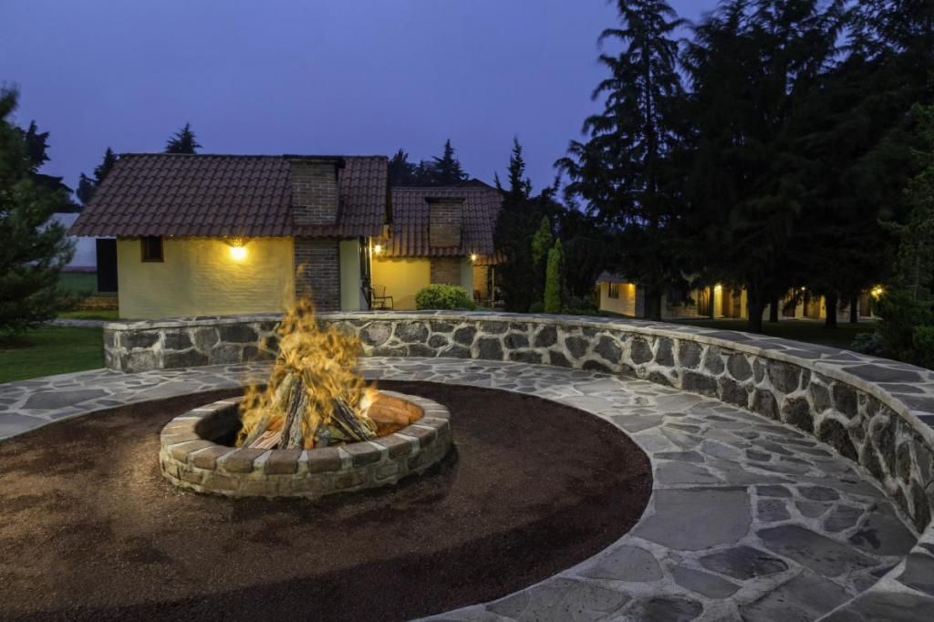 A fire pit in front of a house at night