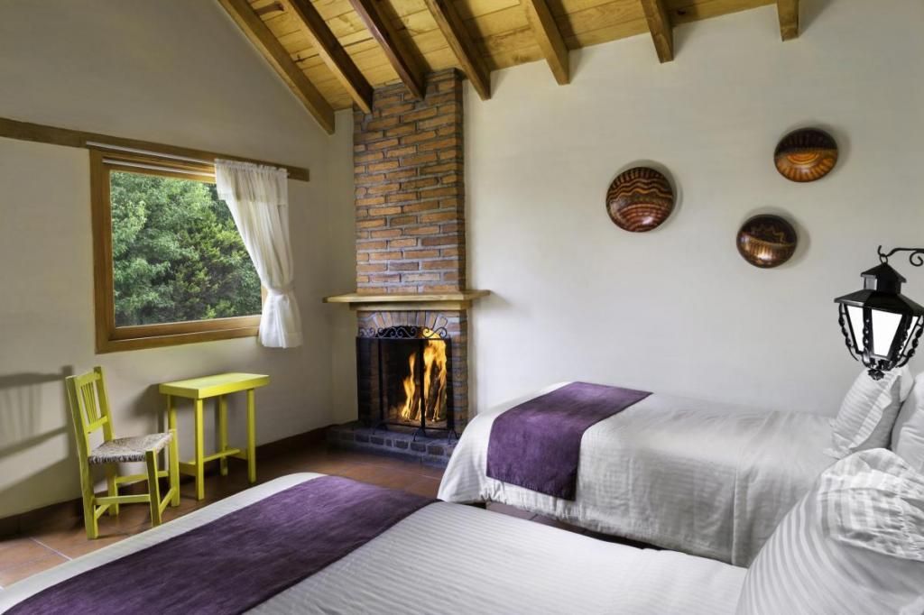 A bedroom with two beds and a fireplace