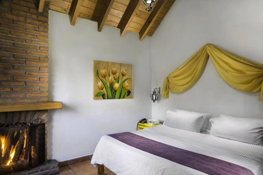 A bedroom with a fireplace and a large bed