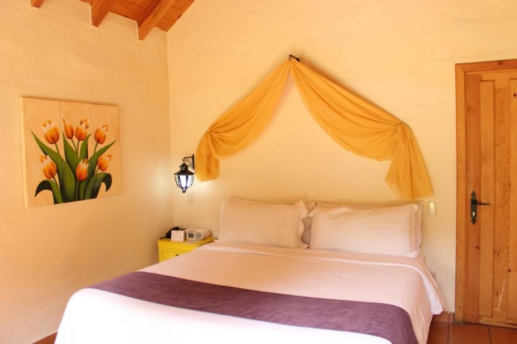 A bedroom with a bed and a picture of flowers on the wall