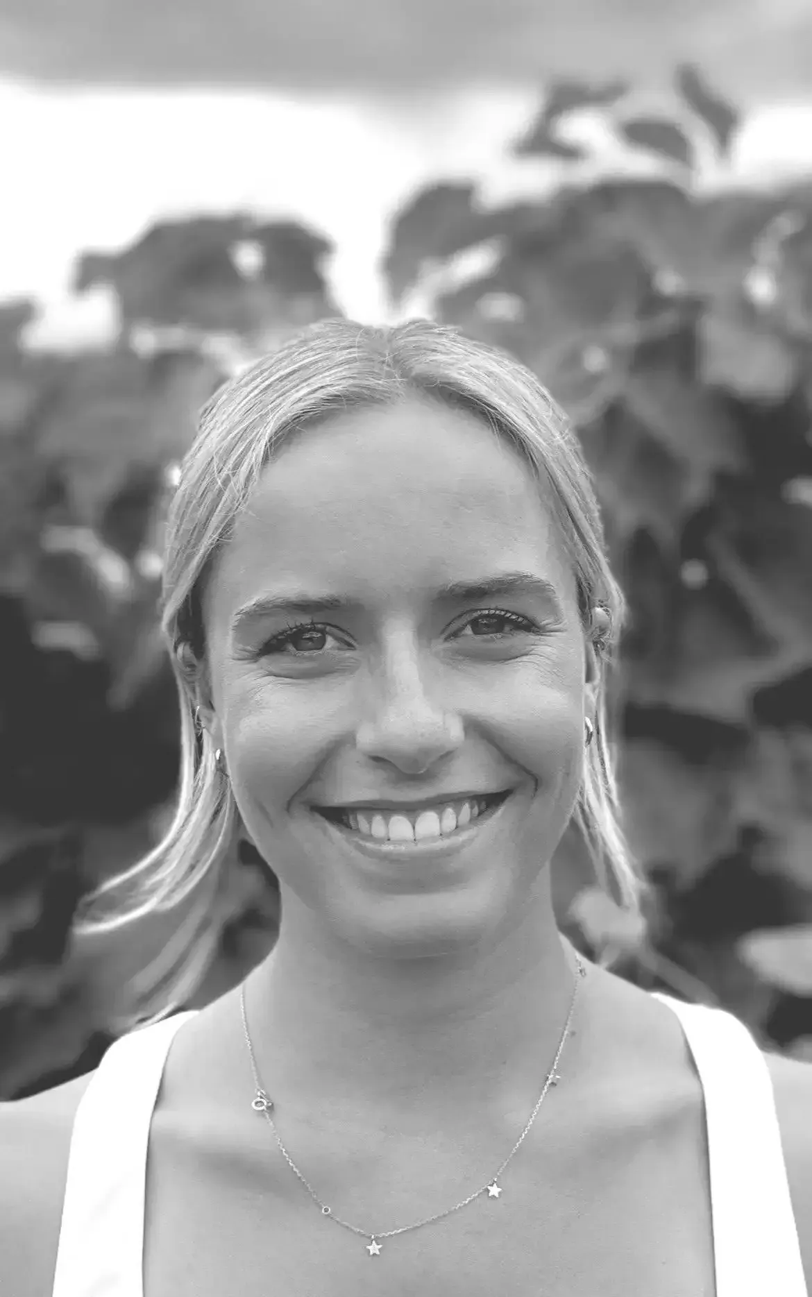 A woman is smiling in a black and white photo.