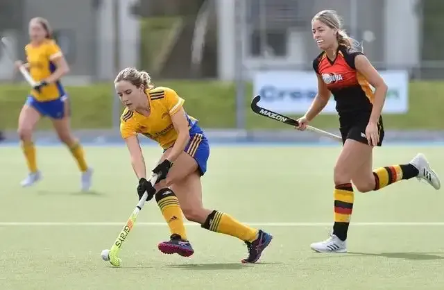 a group of women are playing field hockey on a field .