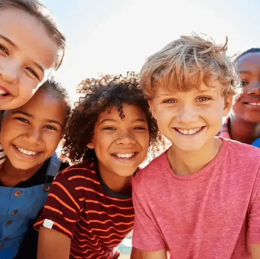 A group of children are posing for a picture together and smiling.