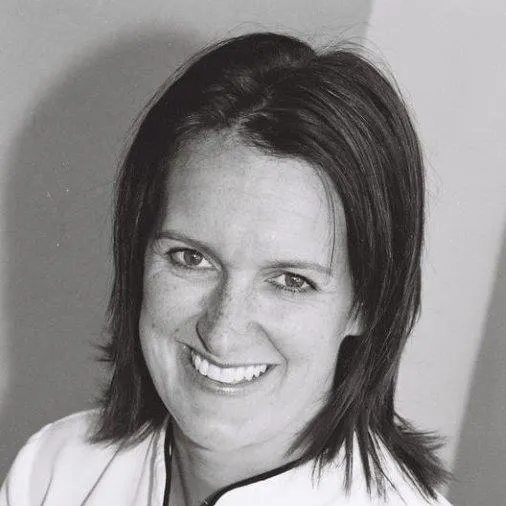 a woman is smiling in a black and white photo .