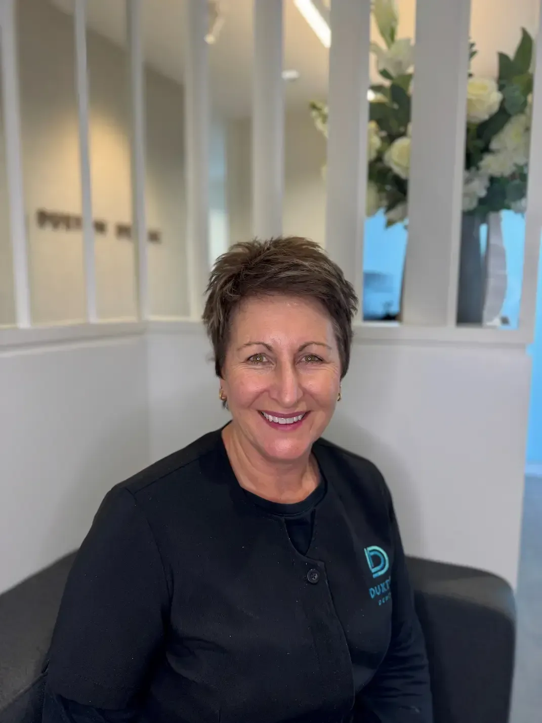 a woman is smiling in a black and white photo .