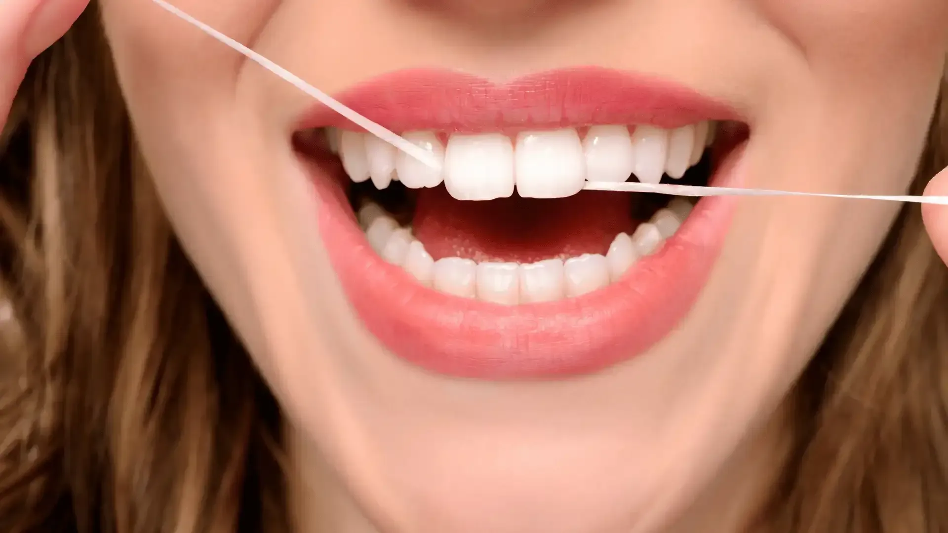 a woman is flossing her teeth with a dental floss .