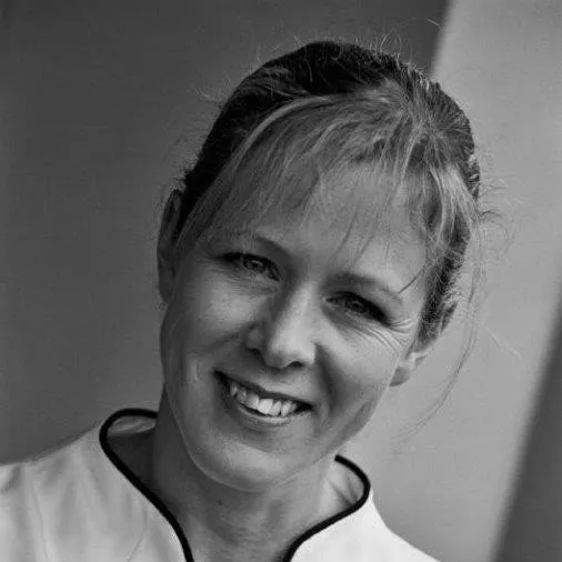 a woman is smiling in a black and white photo .