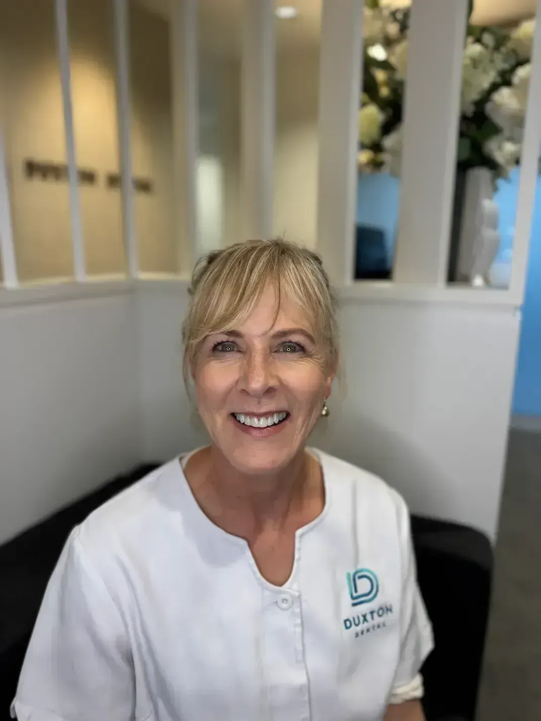 a woman in a white jacket is smiling in a black and white photo .