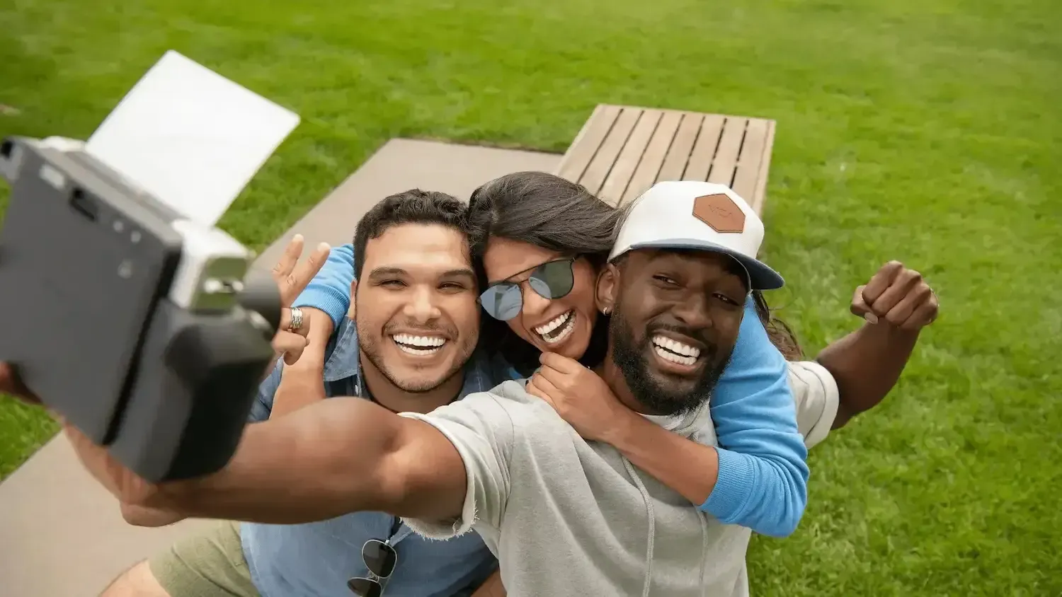 a group of people are taking a selfie with a polaroid camera .