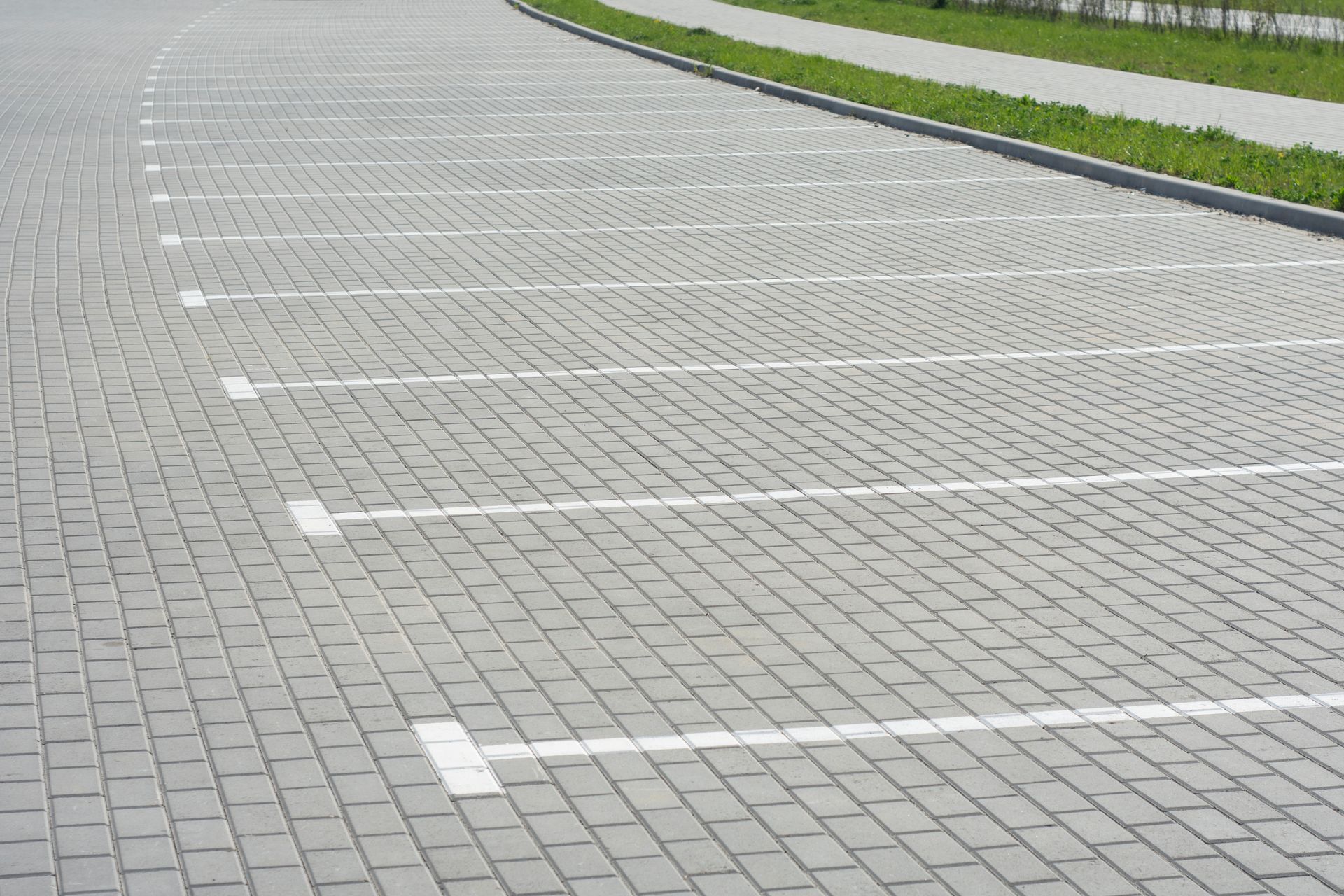 Commercial paving with a newly constructed brick parking lot and marked parking spaces.