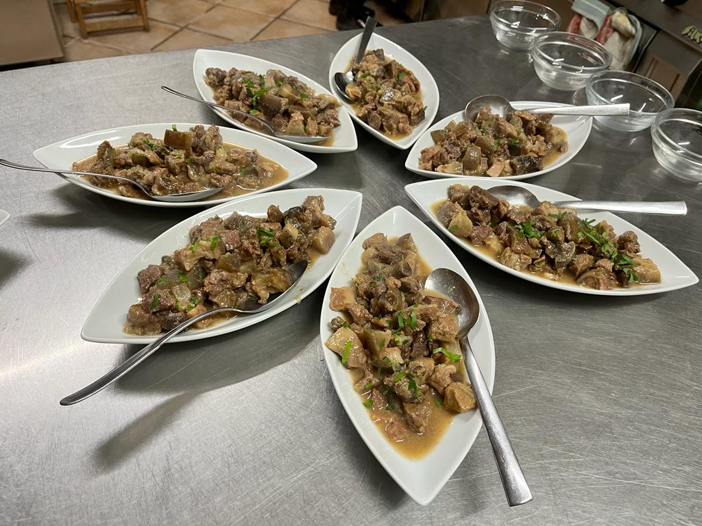 Tre individui con il volto scurito e il capo coperto da foulard, interagiscono all'aperto.