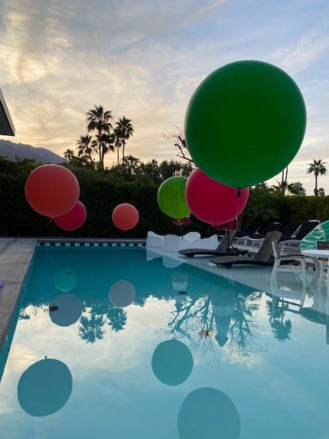 Pink, Orange & Green balloons near pool