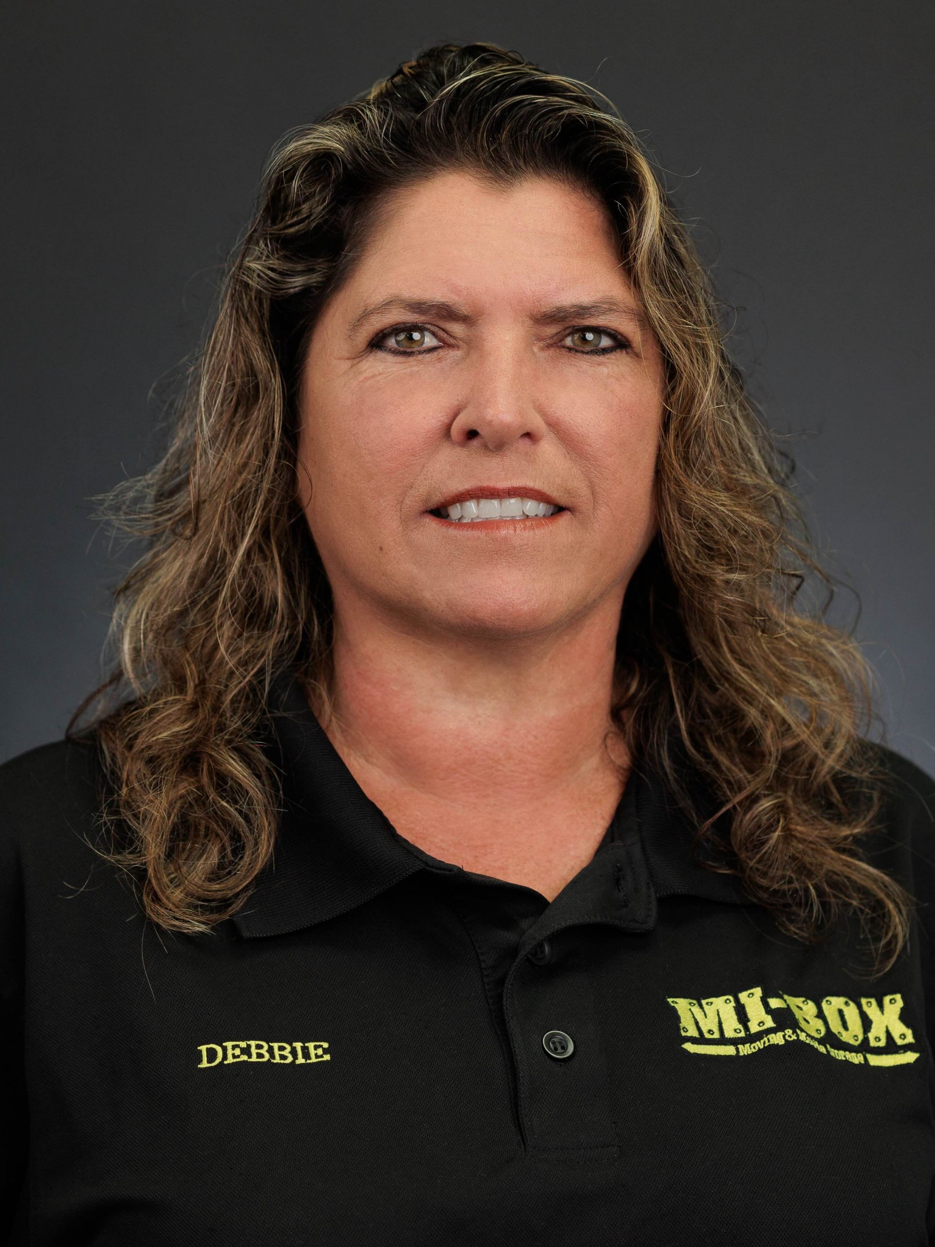 A woman with long hair is wearing a black shirt with the word mi-box on it.