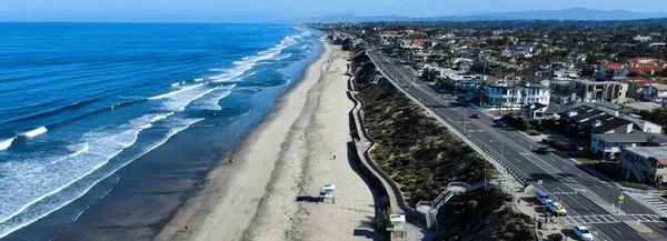 An aerial view of a beach with a highway going through it.